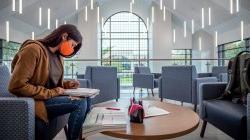 Student sitting in College Hall lounge.